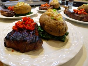 Grilled steaks with pickled pepper relish, twice baked potatoes over sauteed greens.